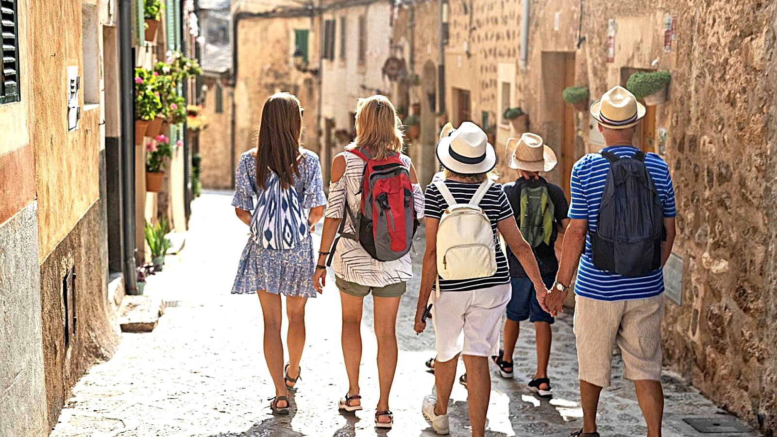 A group of friends walking down a sunlit Mediterranean alley on a private tour